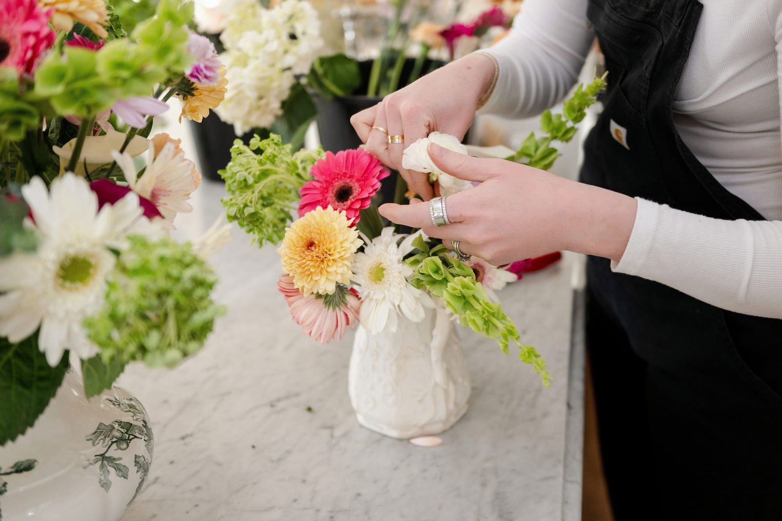 Hands arranging stems in a vase