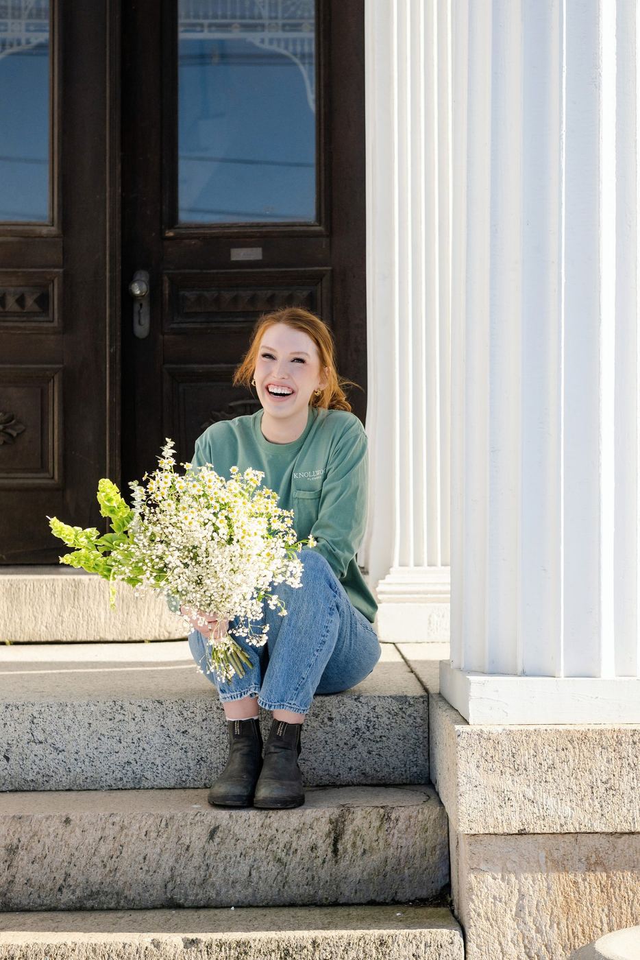 Megan on the front steps with an armful of flowers