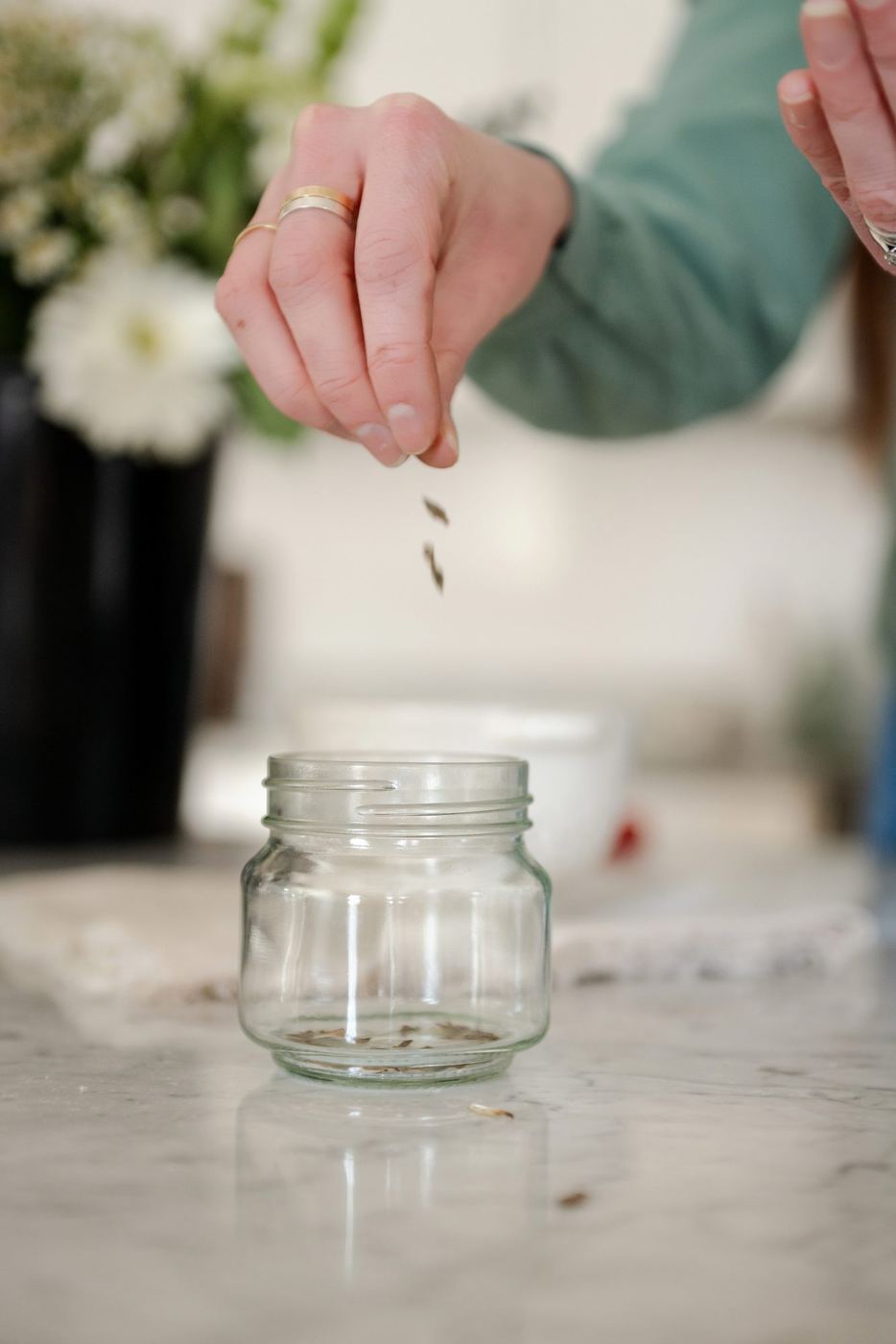 Megan pouring saved seed into a glass jar
